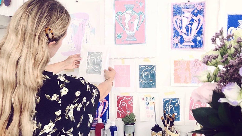 Sasha Compton in her studio in front of artworks that illustrate and celebrate the female form.