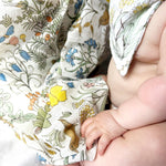 Baby wearing a floral-patterned outfit with a close-up of the fabric.