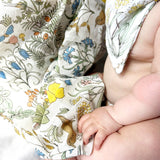 Baby wearing a floral-patterned outfit with a close-up of the fabric.